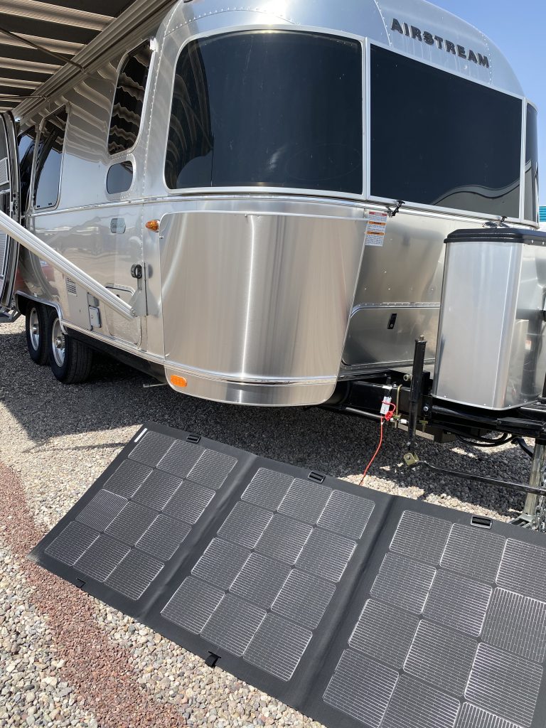 portable solar panels deployed in front of Airstream